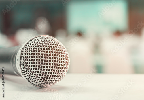Close up microphone wireless old on table in conference and Background blur interior seminar meeting room. Vintage tone color