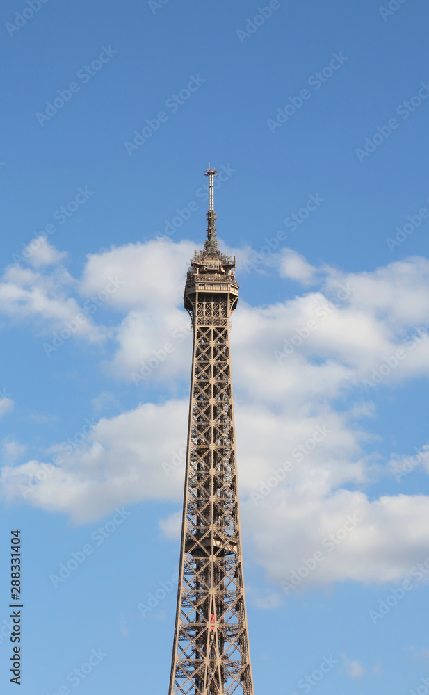Eiffel Tower Symbol of Paris with some white clouds in the blue