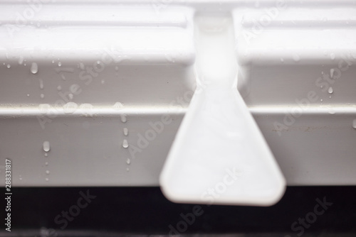 defrosting the refrigerator. water flows down a plastic gutter.