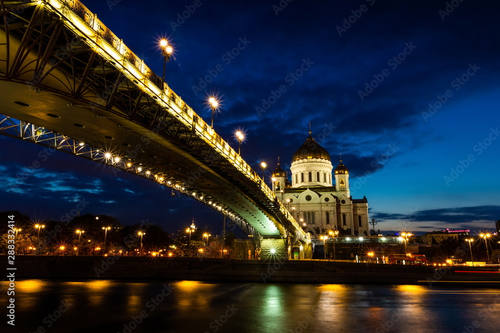 Obraz premium Illuminated Cathedral of Christ the Savior framed with old style street lights of Patriarchy Bridge at night.