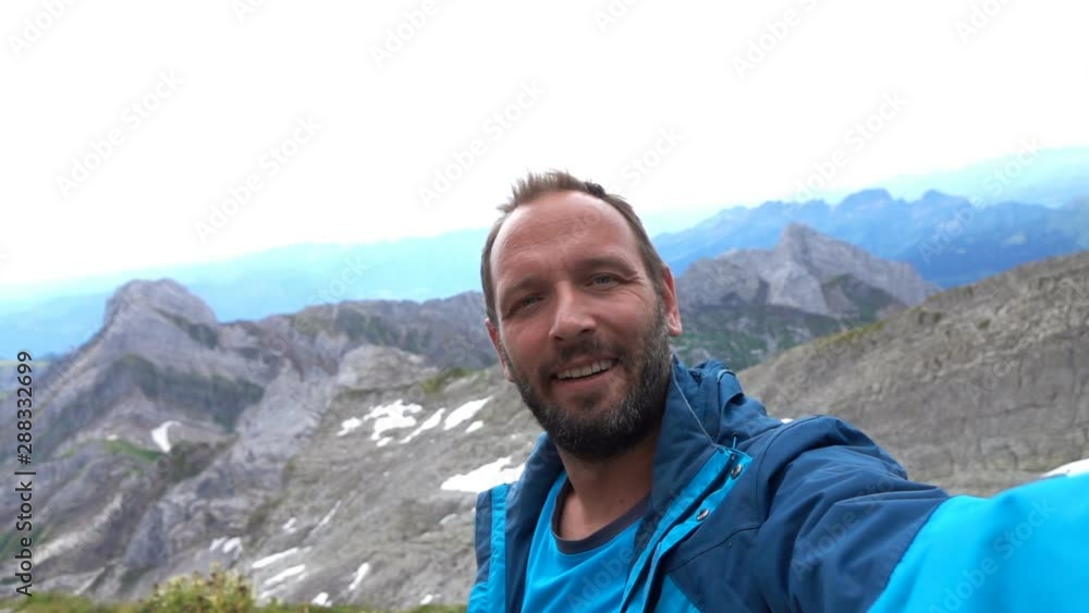 Young, happy man taking selfie photo in mountains, super slow motion Young, happy man taking selfie photo in mountains, super slow motion