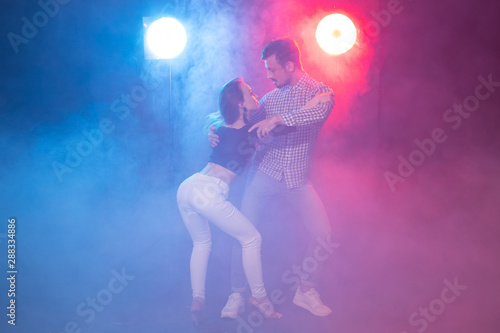 Social dance, bachata, salsa, kizomba, zouk, tango concept - Man hugs woman while dancing over lights