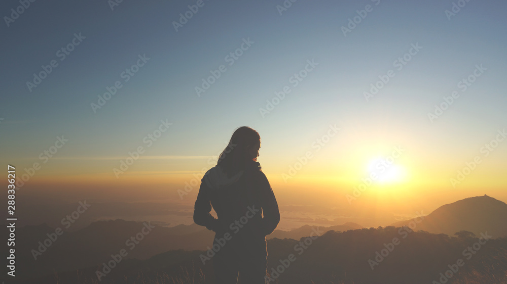 An asian girl is happy with the beautiful sunset and wonderful nature at the mountain An asian girl is happy with the beautiful sunset and wonderful nature at the mountain