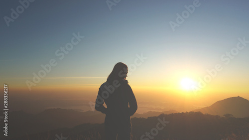 Fototapeta Naklejka Na Ścianę i Meble -  An asian girl is happy with the beautiful sunset and wonderful nature at the mountain