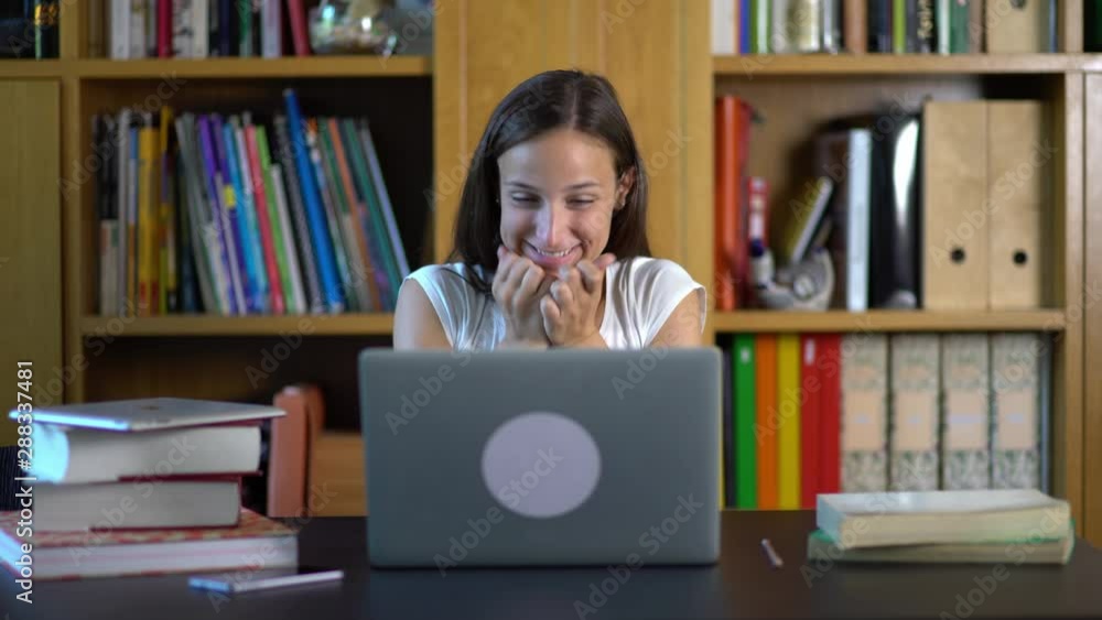Pretty excited happy female student schooler studying using laptop in a modern house. Back to school. Success education college university. Teenager studying. Cine lens. Pretty excited happy female student schooler studying using laptop in a modern house. Back to school. Success education college university. Teenager studying. Cine lens.