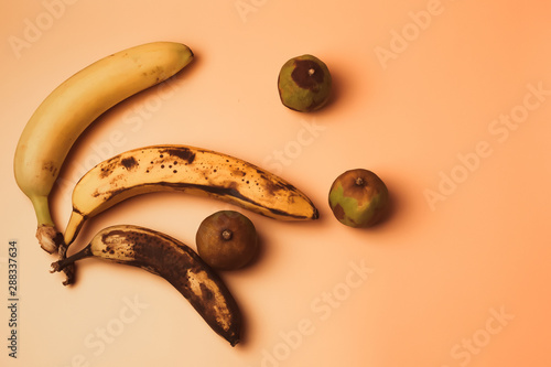 Ugly fruit modification of bananas from ripe to more spoiled brown with spots and decayed limes isolated. The concept of fruit is not salable for supermarkets. photo