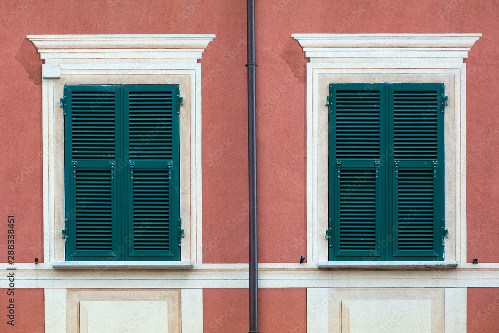 Windows with closed green wooden shutters Windows with closed green wooden shutters