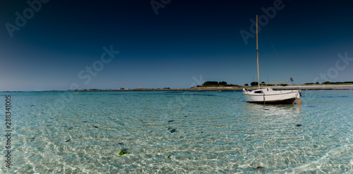 Фотография panorama ocean coast and beach landscape with small sailboat under a blue sky