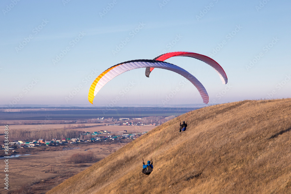 Paraglide with a paraglider in a cocoon against the background of fields of the sky and clouds. Paragliding Sports Paraglide with a paraglider in a cocoon against the background of fields of the sky and clouds. Paragliding Sports