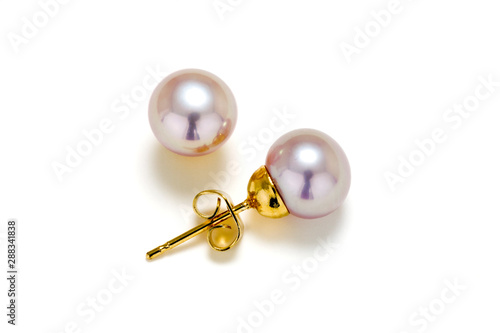 Purple cultured pearls on gold post make up these earring studs. Set on a white background.