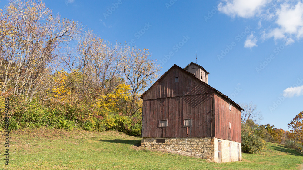 old red barn on a hillside in fall old red barn on a hillside in fall