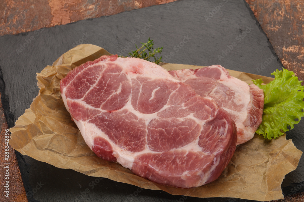 Raw pork steak over wooden board Raw pork steak over wooden board