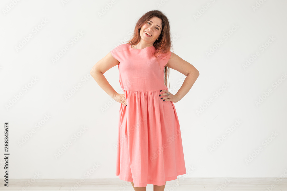 people, fashion and design concept - young woman posing in rose dress on white background with copy space