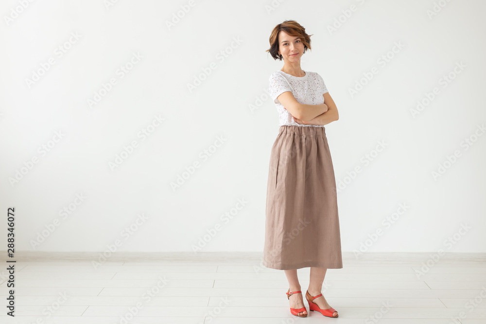 people, fashion and style concept - young woman posing in clothes in studio on white background. people, fashion and style concept - young woman posing in clothes in studio on white background.