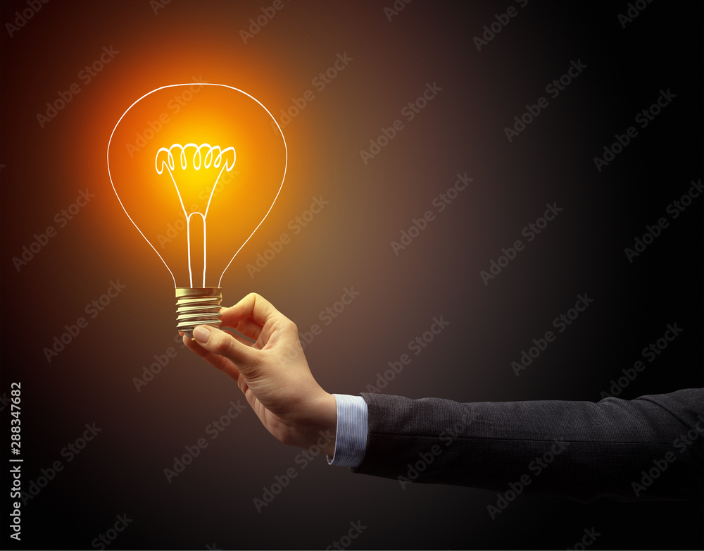 Hand holding light bulb on dark background, new idea concept - obrazy, fototapety, plakaty 