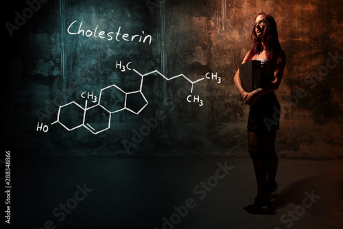 Sexy girl or secretary or female student presenting handdrawn chemical formula of Cholesterol photo