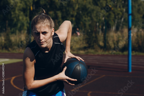 Young woman basketball player playing street ball