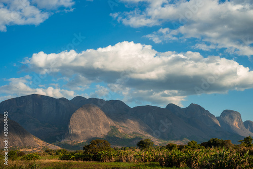Vászonkép A mountain range rises up over lush green vegetation in Mozambique, Africa