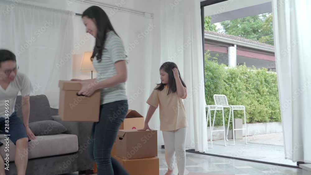 happy Asian family moving to new house with cardboard boxes and arrange the house. happy Asian family moving to new house with cardboard boxes and arrange the house.