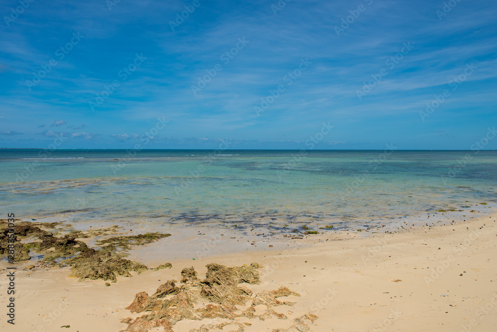 An empty white beach and shallow turquoise water under a sunny blue sky on the Island of Mozambique (Ilha de Mocambique). Nampula Province, Mozambique, Africa