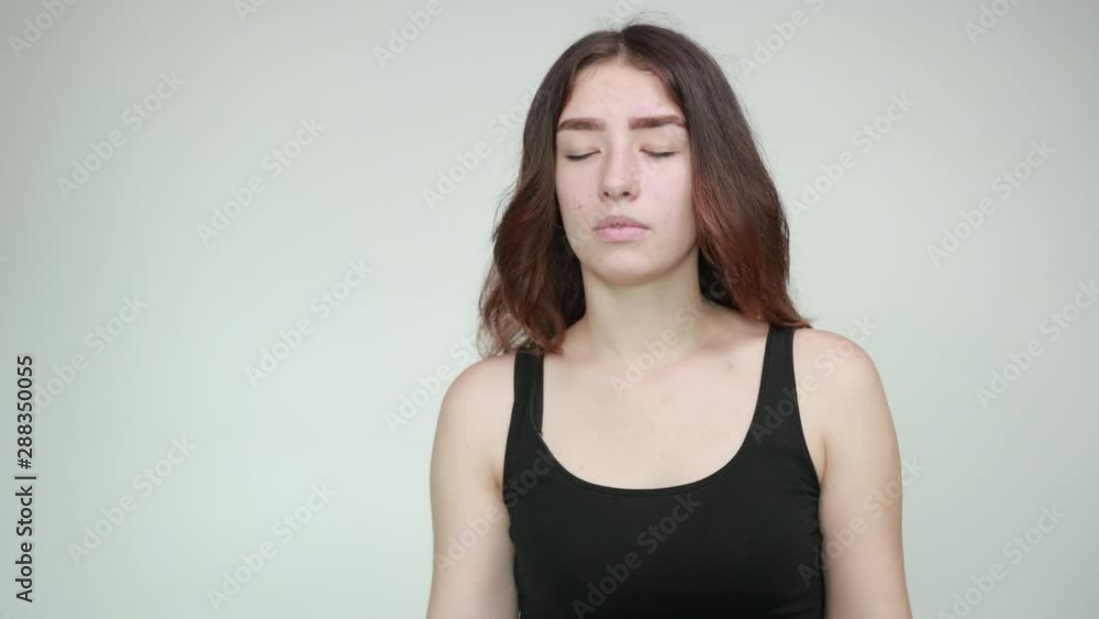 beautiful girl in black tank top over isolated white background shows emotions beautiful girl in black tank top over isolated white background shows emotions