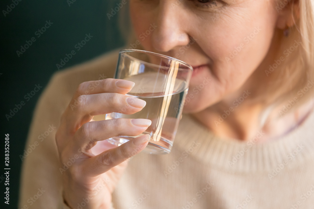 Close up of elderly woman drinking pure mineral water Close up of elderly woman drinking pure mineral water