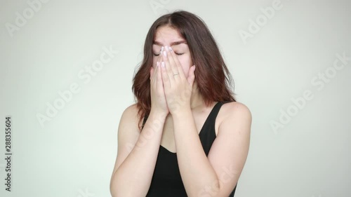 beautiful girl in black tank top over isolated white background shows emotions