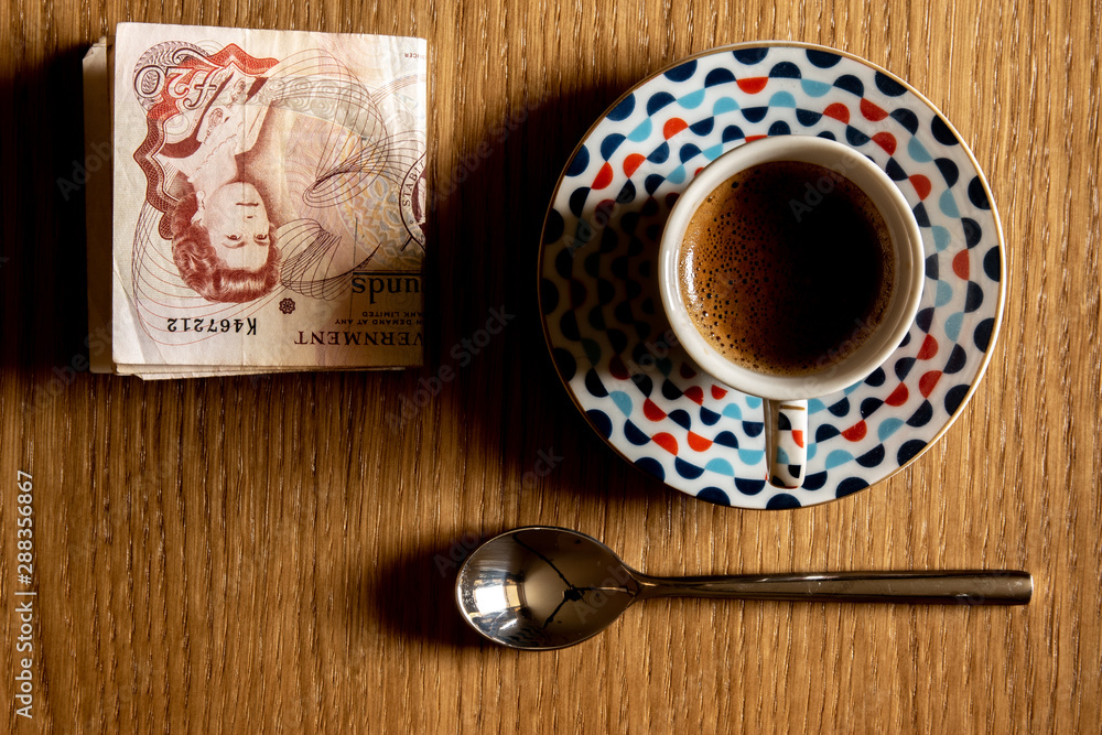 Espresso cup from above on table with spoon and money Espresso cup from above on table with spoon and money