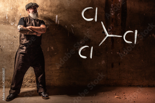 Bearded old man presenting handdrawn chemical formula of trichloromethane cloroform photo