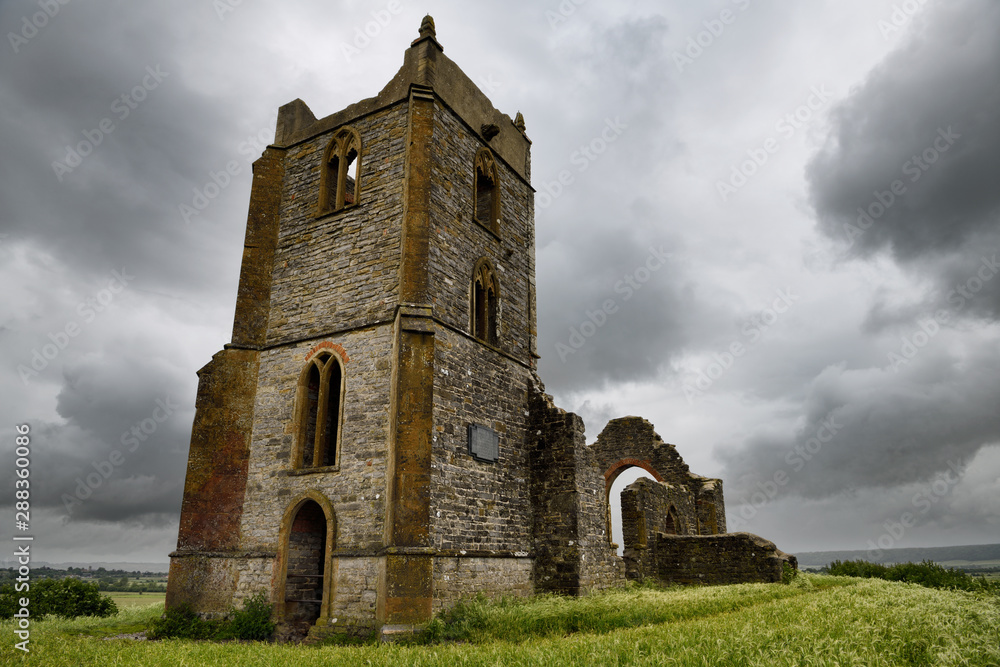Ruins of St Michael's Church on top of Burrow Mump overlooking Southlake Moor in Burrow Bridge England under cloudy sky Ruins of St Michael's Church on top of Burrow Mump overlooking Southlake Moor in Burrow Bridge England under cloudy sky