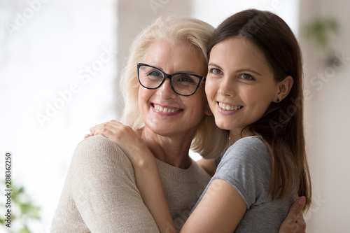 Smiling mother and daughter posing for picture together