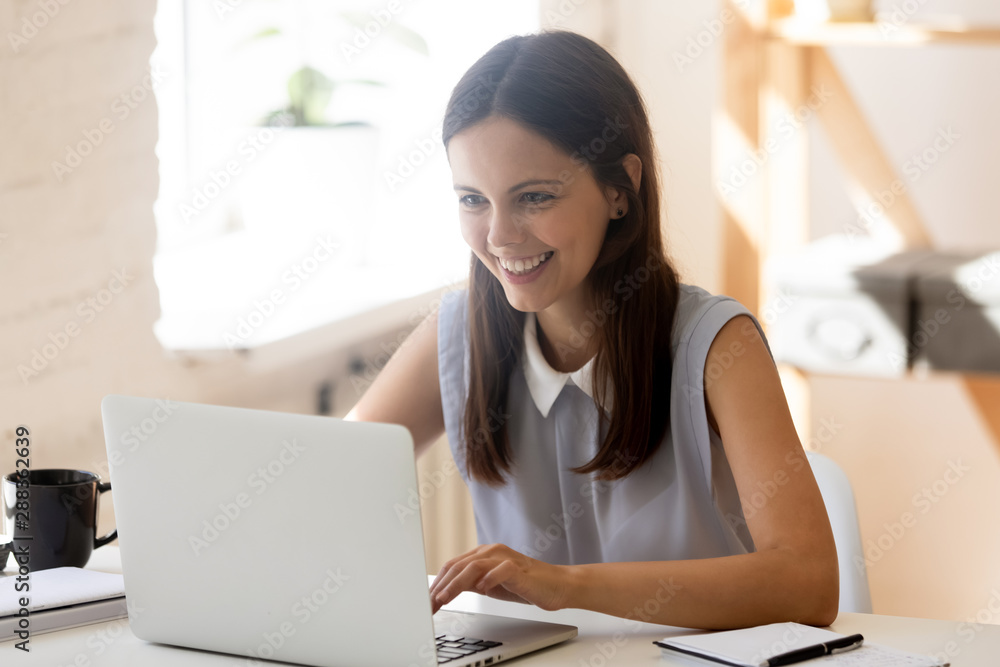 Happy young woman working at laptop at home Happy young woman working at laptop at home