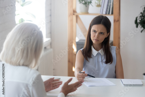Frustrated female recruiter feel dubious talking with applicant
