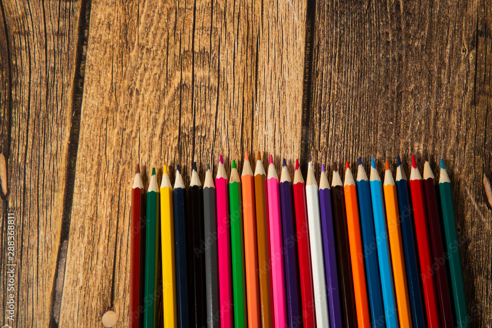 Colored pencils on a wooden brown background. Drawing tool. Colored pencils on a wooden brown background. Drawing tool.