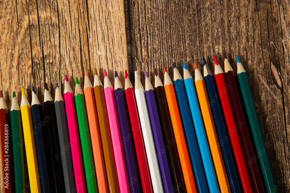 Colored pencils on a wooden brown background. Drawing tool. Colored pencils on a wooden brown background. Drawing tool.