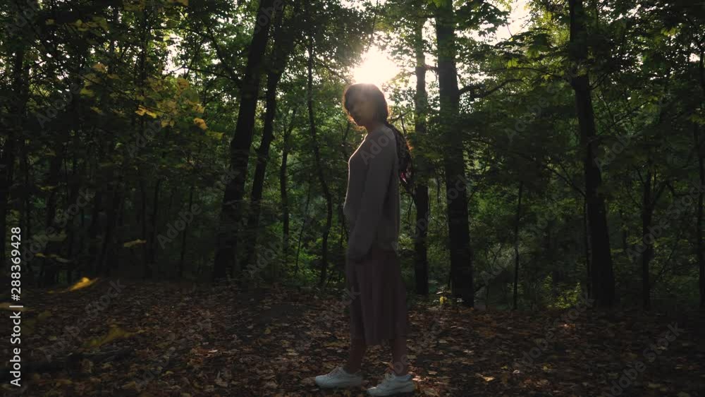 Beautiful curly girl poses and walks in the forest. She smiled sweetly and has braces on her teeth. Beautiful curly girl poses and walks in the forest. She smiled sweetly and has braces on her teeth.