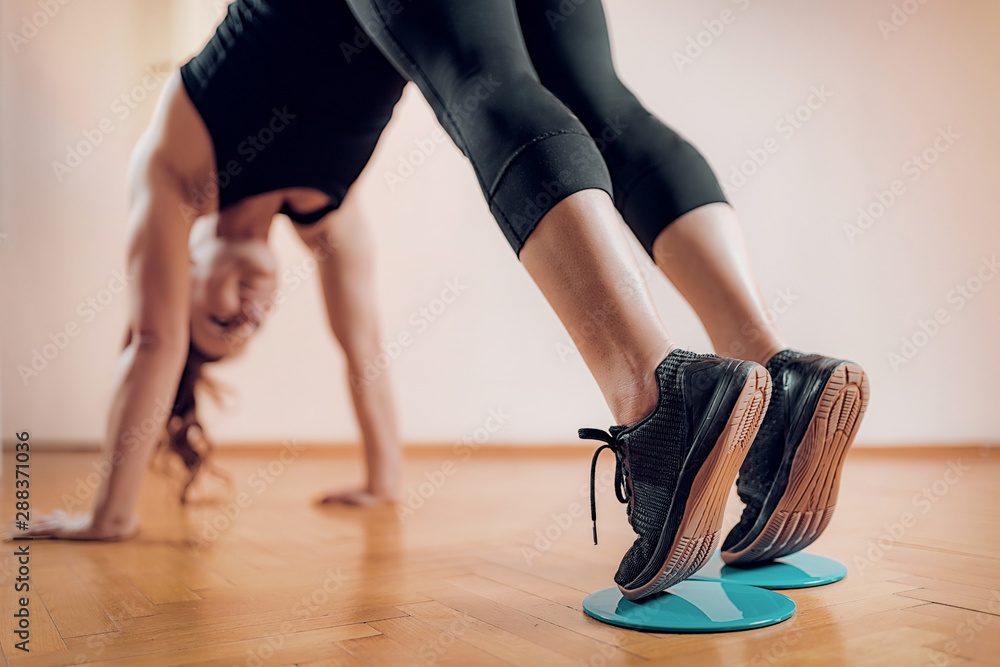 Female Athlete Exercising with Sliding Discs. Female Athlete Exercising with Sliding Discs.