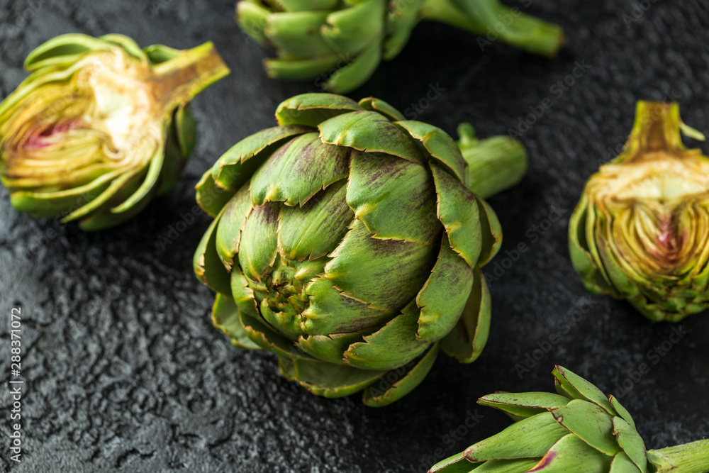 Obraz premium Fresh raw organically grown artichoke flower buds on dark background