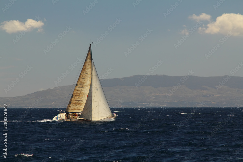 Sailing ship yachts with white sails in race the regatta in the open sea.