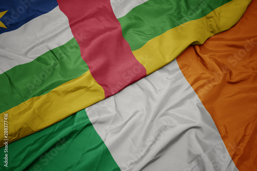 waving colorful flag of ireland and national flag of central african republic.