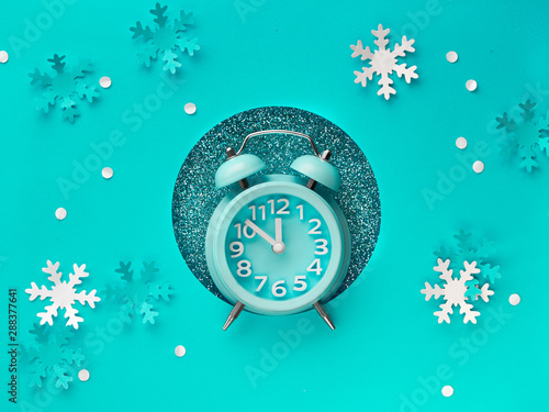 Happy New Year 2020! Aarm clock in paper hole, flat lay on mint color paper photo