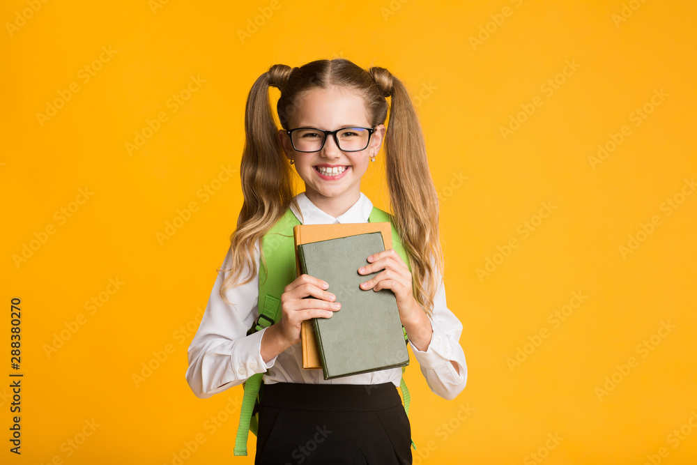 Happy Schoolgirl Holding Books Smiling At Camera, Studio Shot Happy Schoolgirl Holding Books Smiling At Camera, Studio Shot
