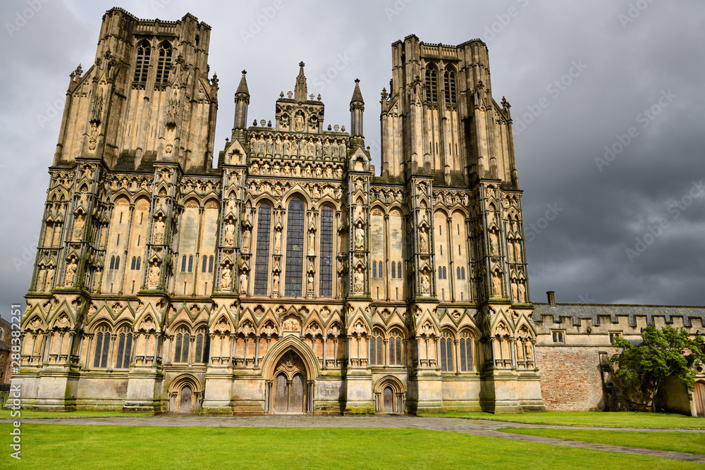 Sun on stone sculptures on the West front facade of Wells Cathedral after a rain storm Wells England