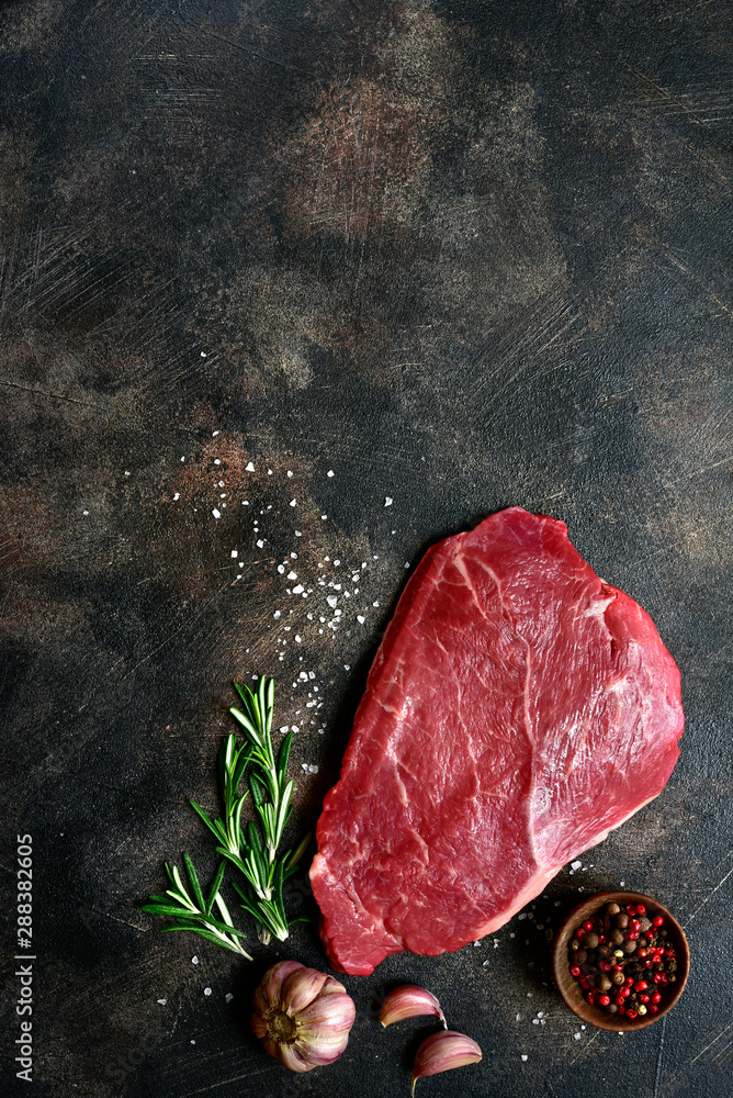 Raw beef steak with spices. Top view with copy space.