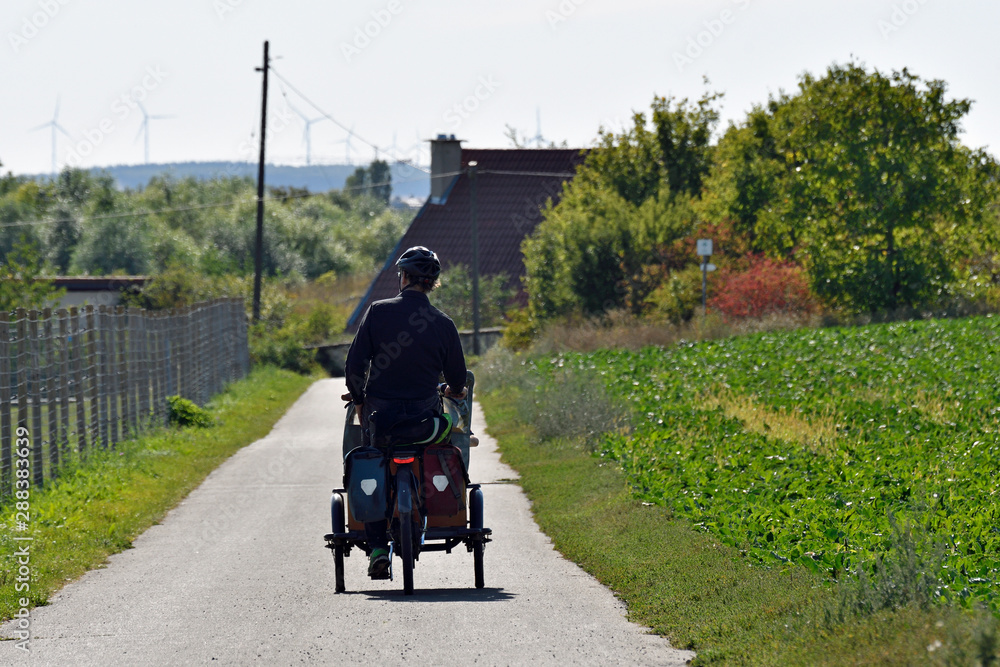 Obraz premium dreiradfahrer auf einem feldweg