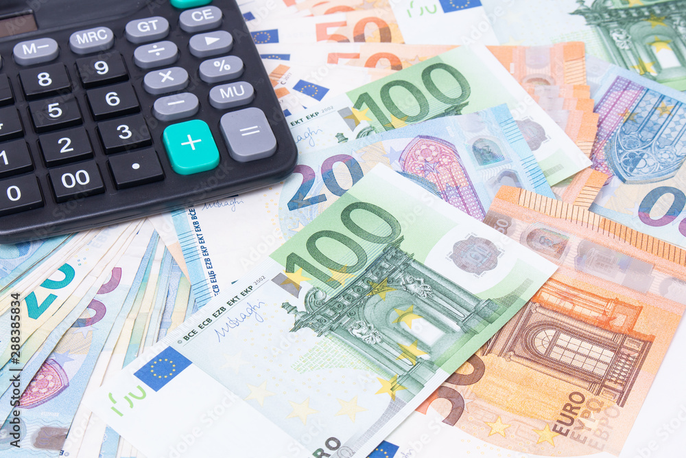 Close-up of calculator on Euro banknotes. Euro money bills to pay. Finances and budget concept. Tax and money. Close-up of calculator on Euro banknotes. Euro money bills to pay. Finances and budget concept. Tax and money.