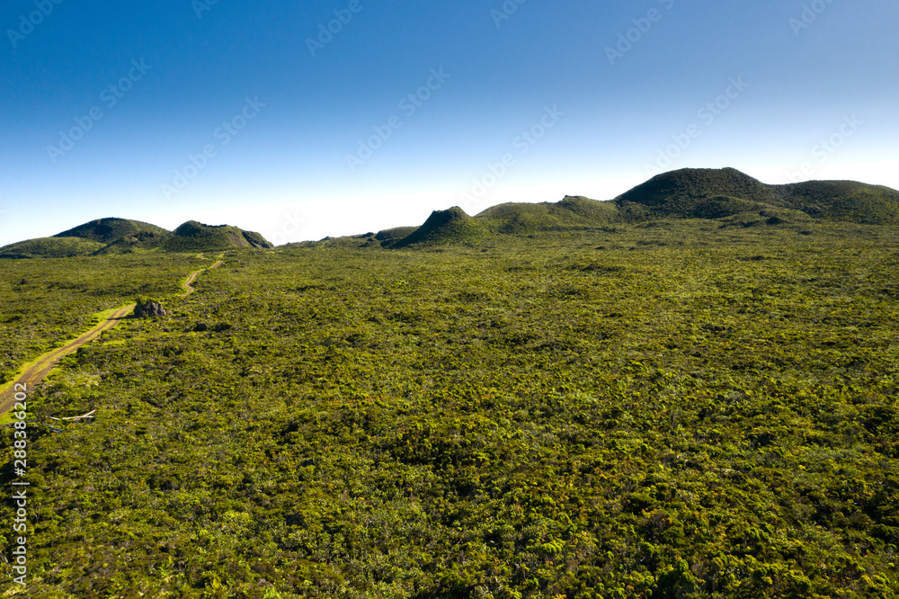 Obraz premium Aerial image of typical green volcanic caldera crater landscape with volcano cones of Planalto da Achada central plateau of Ilha do Pico Island, Azores