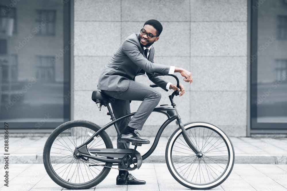 Fototapeta premium Keep calm and ride on. Businessman cycling against office buiding