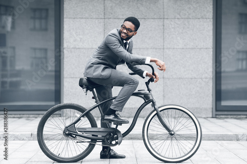 Keep calm and ride on. Businessman cycling against office buiding