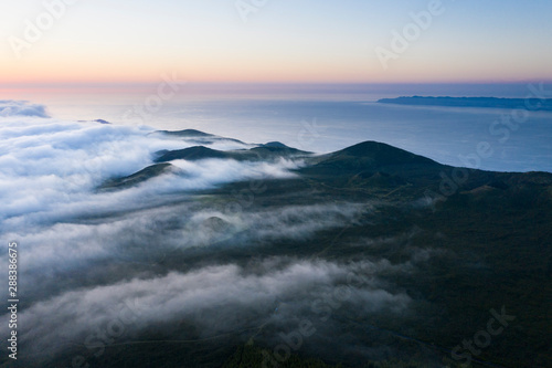 Aerial image with magical sunset over a low cloud layer covering Pico Island, with the northcoast and Sao Jorge Island in the background, Azores